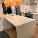 bianco nevoso white quartz island in white kitchen